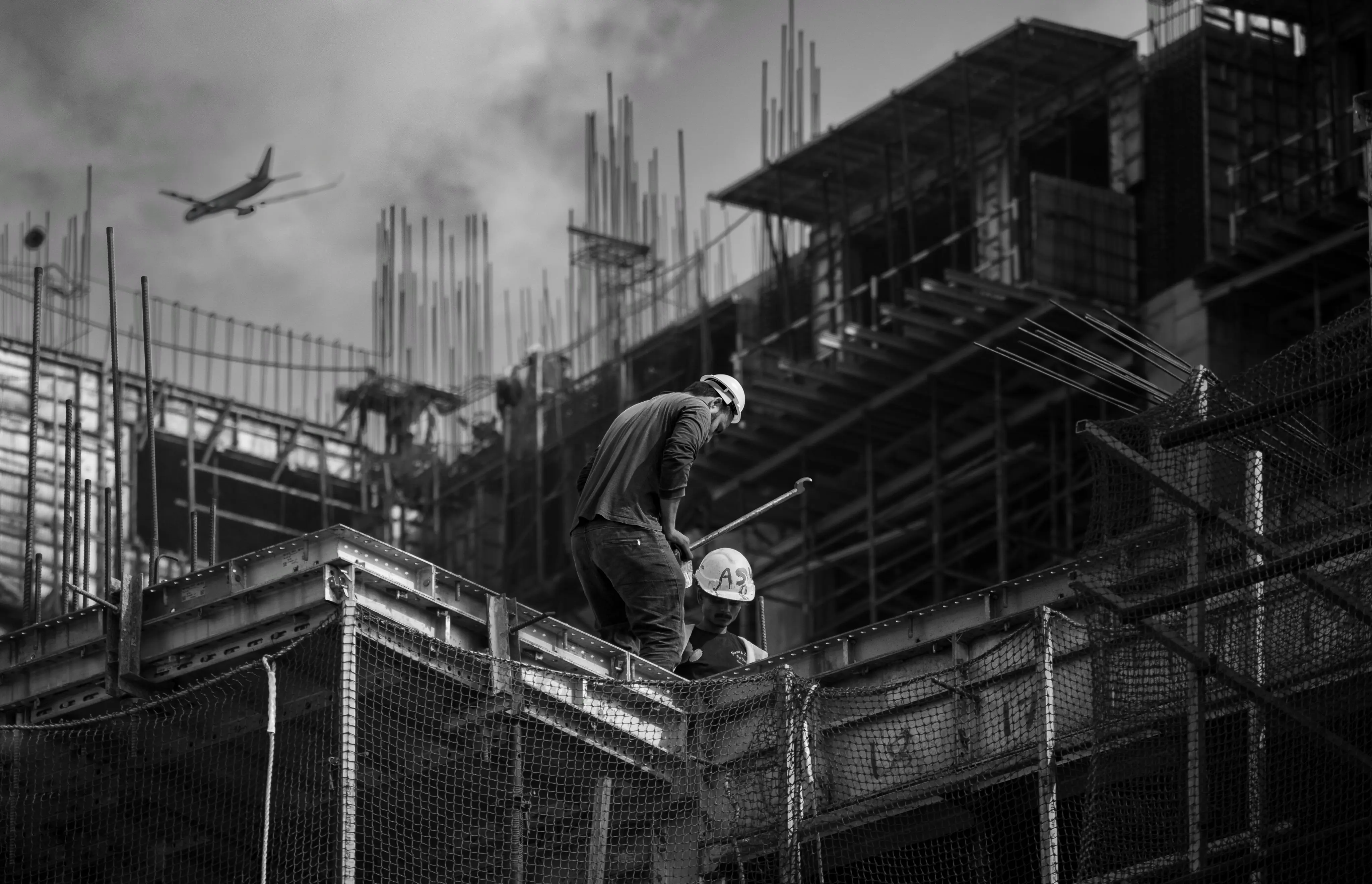 Workers assembling scaffolding on a building site